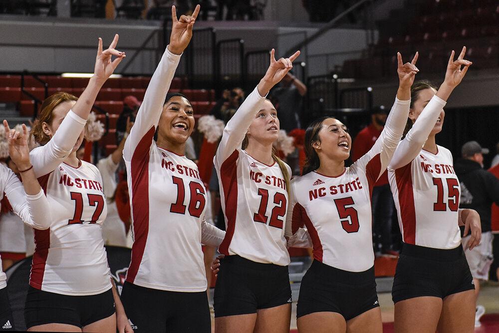 The NC State women's volleyball team hold up "Wolfies" at the conclusion of their game against Florida State on Friday, Sept. 30, 2022 in Reynolds Coliseum. NC State beat Florida State 3-0.