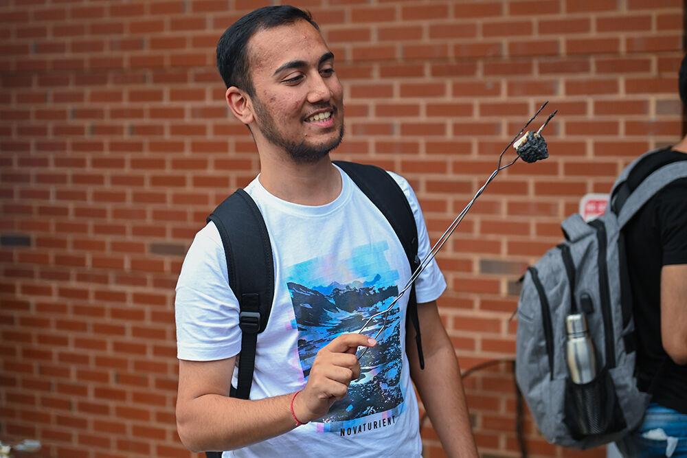 Shubham Saboo, a graduate studying computer science, looks at his charred marshmallow at the Wellness and Recreation Center on Tuesday, Aug. 22, 2023. The event consisted of students roasting marshmallows and making s'mores.