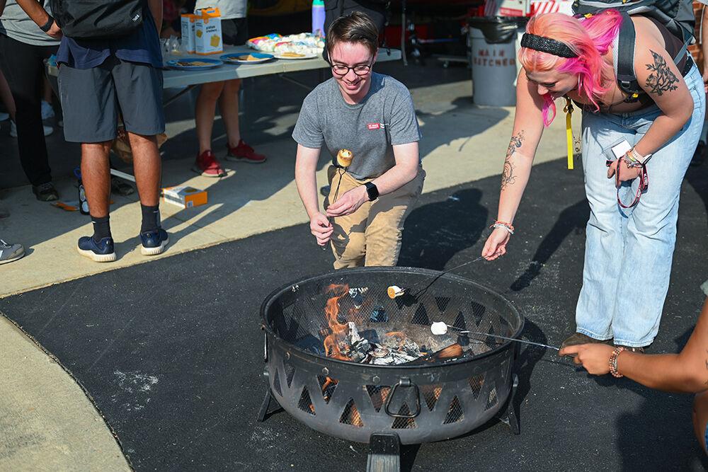 Sky Johnson, a fourth-year studying checmical engineering and paper science engineering, pulls his roasted marshmallow out of the fire at the Wellness and Recreation Center on Tuesday, Aug. 22, 2023. The event consisted of students roasting marshmallows and making s'mores.