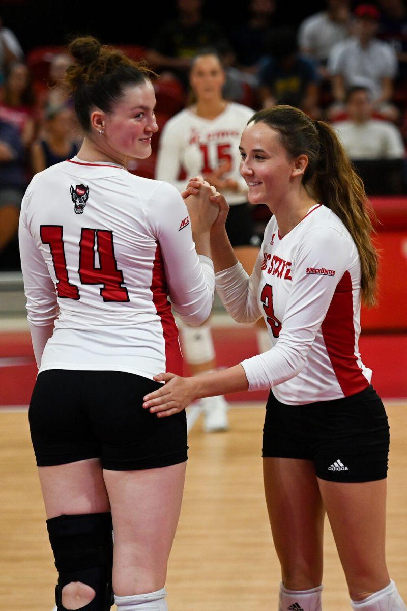 Junior outside hitter Martyna Leoniak and freshman outside hitter Clara Vondran high-five during the match against George Washington University at Reynolds Coliseum on Wednesday, Sept. 13, 2023. NC State beat George Washington with a score of 3-0.