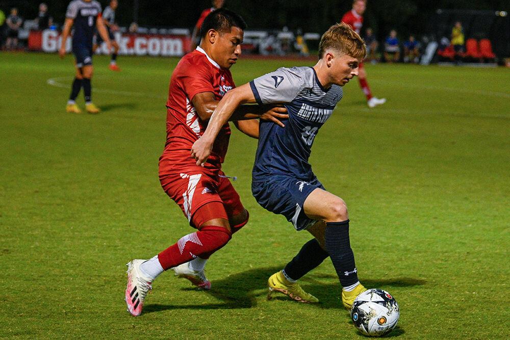 Freshman forward Ervin Cruz grabs his opponent in an attempt to steal the ball during the match against the University of North Florida at Dail Soccer Field on Wednesday, Sept. 20, 2023. NC State beat the University of North Florida 1-0.