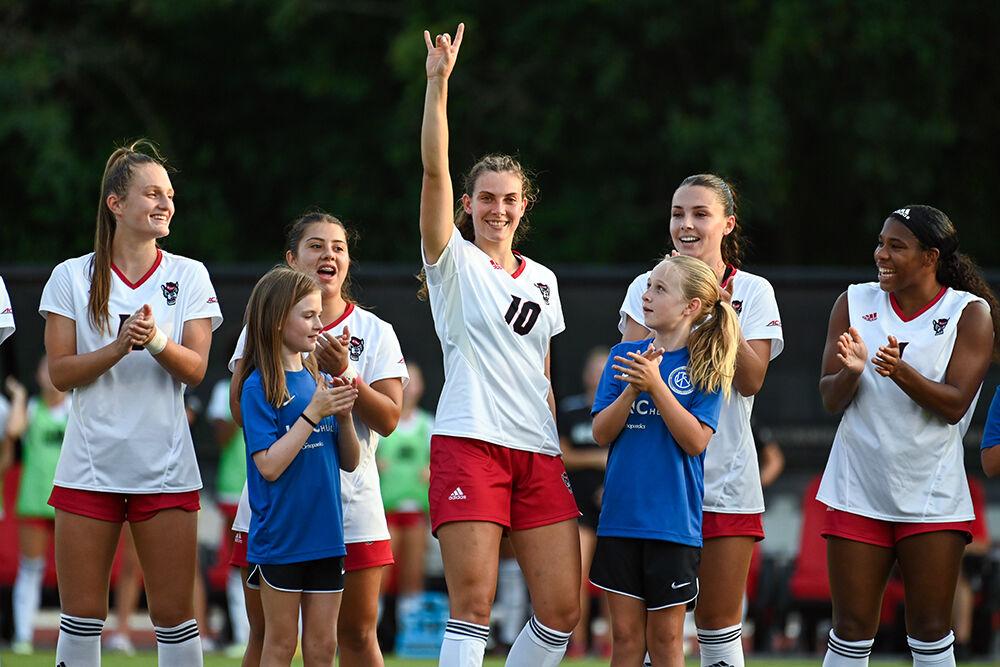 Junior midfielder Annika Wohner holds up a "wolfie" during the starting lineup announcement before the match against Rutgers at Dail Soccer Field on Thursday, Aug. 24, 2023. Wohner scored one goal for the Wolfpack. NC State and Rutgers tied 1-1.