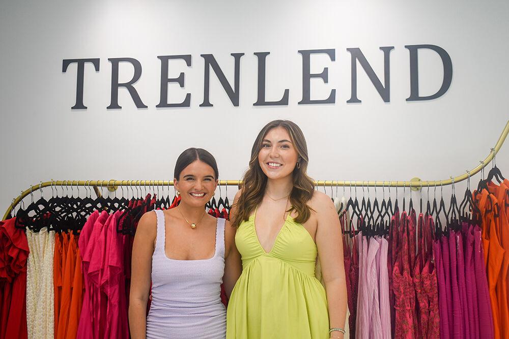 Amelia Zahn (left), a fourth-year studying business administration, and Emmy Weiland (right), a fourth-year studying business administration, stand in front of their company's logo at the TrenLend storefront in Cary, NC, on Wednesday, Aug. 30, 2023. TrenLend is a one-of-a-kind clothing rental store that allows customers to try on pieces before renting them.