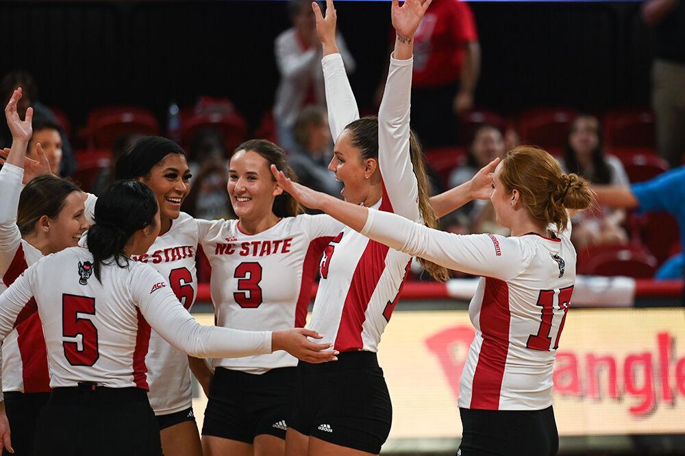 The NC State volleyball team celebrates their victory after the match against George Washington University at Reynolds Coliseum on Wednesday, Sept. 13, 2023. NC State beat George Washington with a score of 3-0.