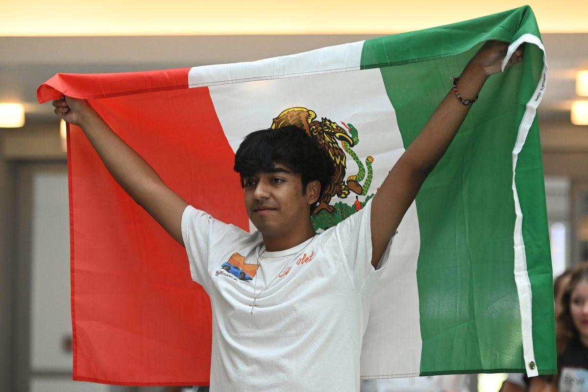 Eduardo Sanchez, a second-year studying mechanical engineering, holds up the Mexican flag at the Latinx Heritage Month Kickoff in Talley Student Union on Friday, Sept. 15, 2023. Latinx Heritage Month Kickoff was an event that allowed students to connect with the different Latinx organizations on campus.