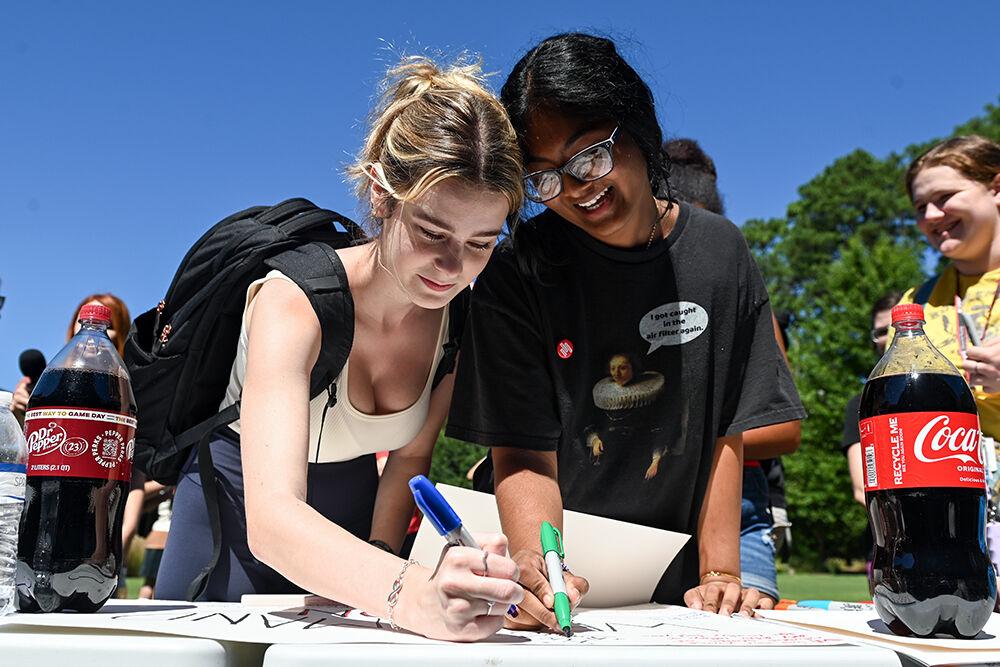 Beth Fletcher, a first-year studying social work, and Udita Pericharla, a first-year in exploratory studies, laugh while making signs during the state-wide walkout at Stafford Commons on Friday, Sept. 15, 2023. The walkout was held by the NC State Students Demand Action and March for Our Lives organizations to protest gun violence.
