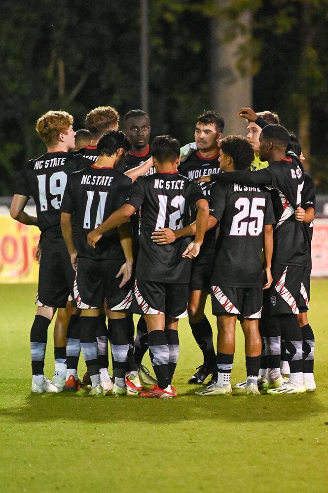 Members of the men's soccer team regroup during the match against the American University Eagles at Dail Soccer Field on Tuesday, Oct. 10, 2023. The Wolfpack lost to the Eagles 2-1.