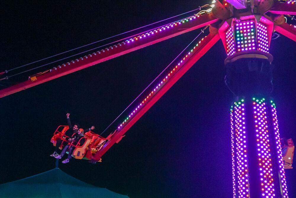 A fairgoer throws their hands in the air along side their ride partner at the North Carolina State Fair in Raleigh on Sunday, Oct. 15. 2023. The fair was held from Oct. 12-22, 2023.