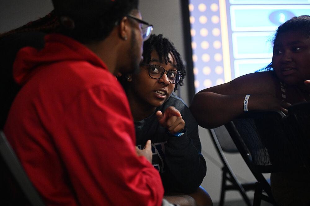 Nayah McKenzie, a second-year studying computer engineering, talks to Chris Virella, a fourth-year studying industrial systems engineering, and Shayla Waugh, a second-year studying animal science, during Family Feud at Witherspoon Student Center on Friday, Oct. 6, 2023. This was one of the many events held during National Pan-Hellenic Council Week at NC State.