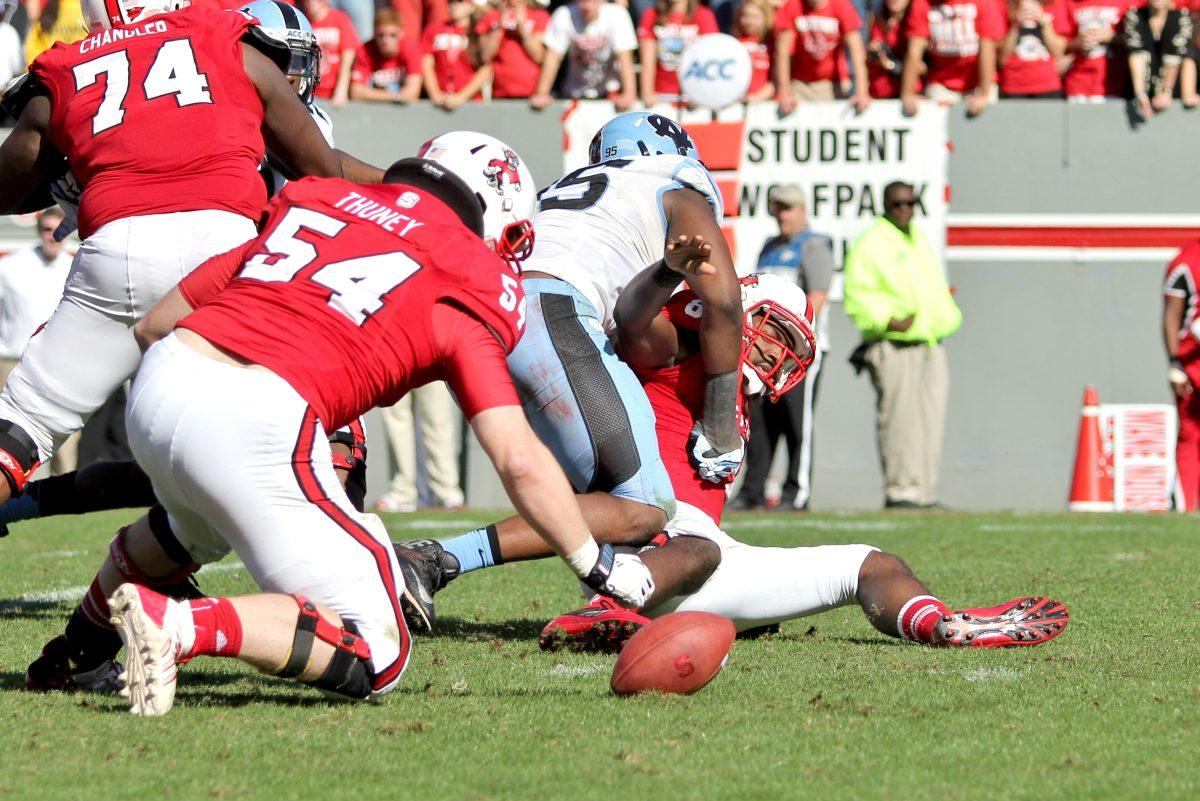Redshirt sophomore center Joe Thuney recovers a fumble by graduate quarterback Brandon Mitchell during the second quarter of the homecoming game against Carolina Saturday, Nov. 2 2013 in Carter-Finley Stadium. The Wolfpack had a total of three fumbles during the game against the Tar Heels.