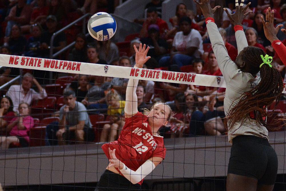 Sophomore outside hitter Courtney Bryant hits the ball past blockers during the match against Louisville in Reynolds Coliseum on Sunday, Oct. 1, 2023. Bryant made 13 digs. The Wolfpack defeated the Cardinals 3-1.