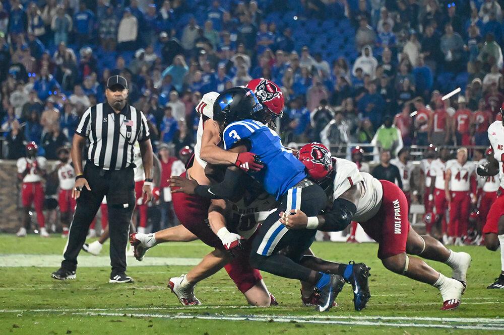 Graduate linebacker Payton Wilson and Junior defensive tackle Davin Vann tackle the Blue Devils quarterback during the Wolfpack's game against the Duke Blue Devils at Wallace Wade Stadium on Saturday, Oct. 14, 2023. Wilson had 11 tackles and Vann had 3 tackles. The Blue Devils beat the Wolfpack 24-3.