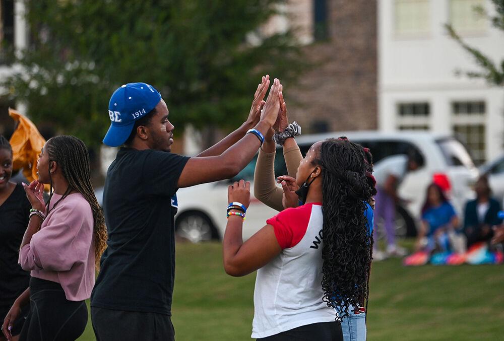 Adrian Gibbs, a fourth-year studying science, technology and society, gives a high five to participants during the NPHC Olympic Games at Stewardship Park on Wednesday, Oct. 4, 2023. NPHC Week consist of collaborated events from organizations in the National Pan-Hellenic Council on NC States campus.