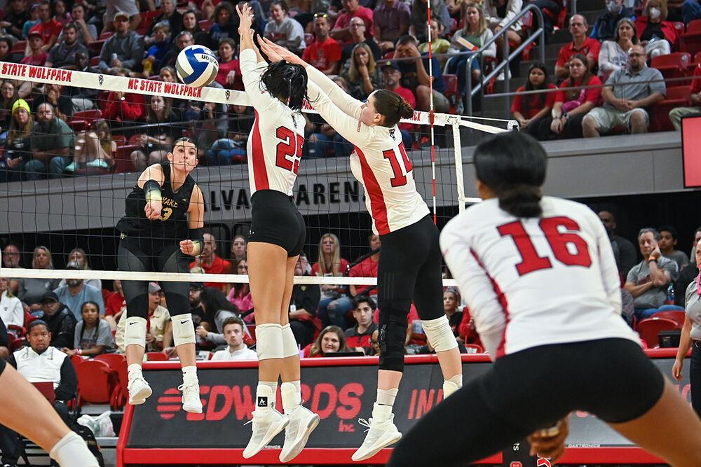 Senior middle blocker Riley Shaak (left), and junior outside hitter Martyna Leoniak (right), attempt to block a hit from their opponent during the match against Wake Forest in Reynolds Coliseum on Friday, Oct. 13, 2023. The Wolfpack defeated the Demon Deacons 3-1.