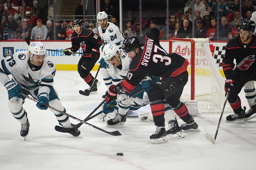 Carolina right wing Andrei Svechnikov battles San Jose defenders for the puck during the Carolina Hurricanes' home game against the San Jose Sharks in PNC Arena on Friday, Jan. 27, 2023. Svechnikov had two assists as the Canes came from behind by scoring three unanswered goals and beat the Sharks 5-4 in overtime.