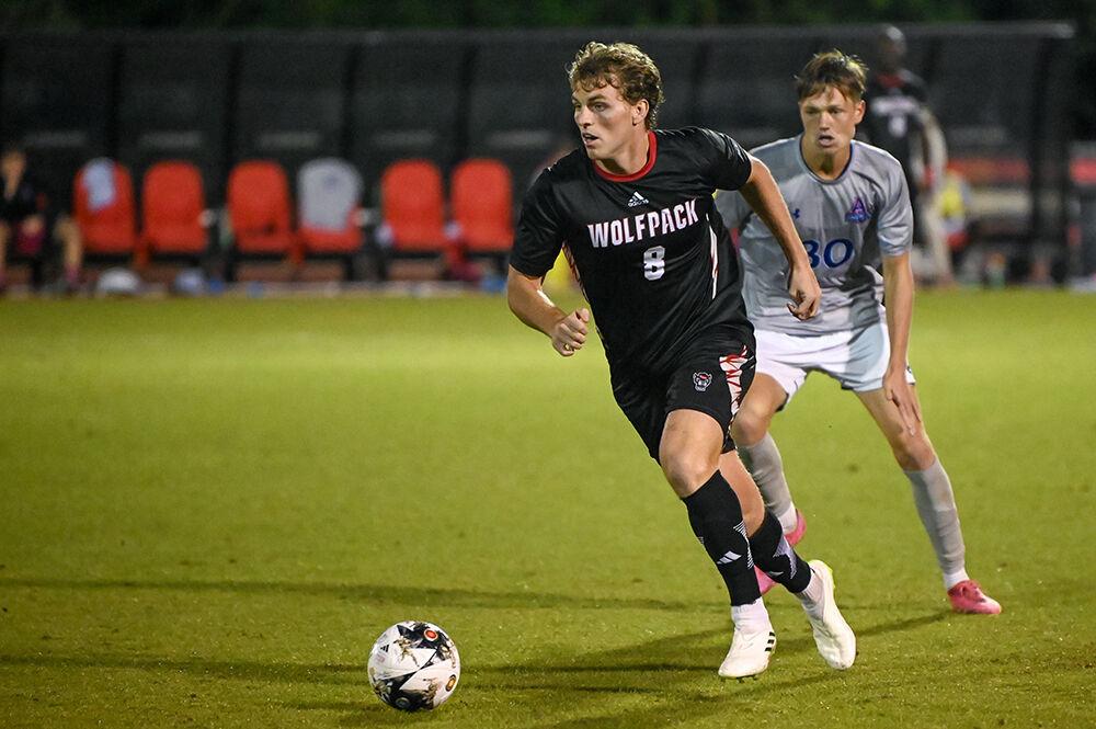 Junior midfielder Will Buete moves the ball downfield during the match against American at Dail Soccer Field on Tuesday, Oct. 10, 2023. Buete made one assist for the Wolfpack. NC State lost the match 2-1.