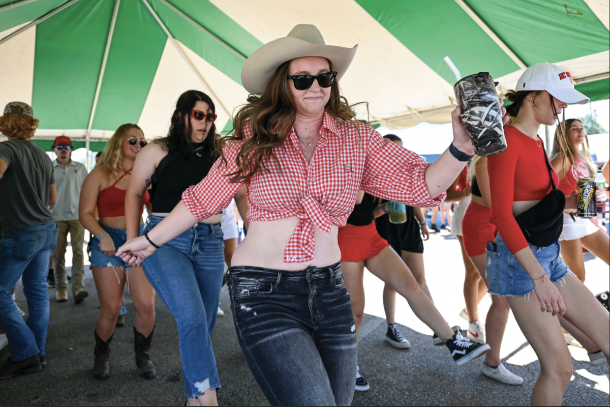 Savannah Frye, a fourth-year in communications at Meredith College, line dances with friends during the tailgate at the fairgrounds lot outside of Carter-Finley Stadium on Saturday, Sept. 16, 2023. Students were tailgating for the football game against VMI.
&#160;