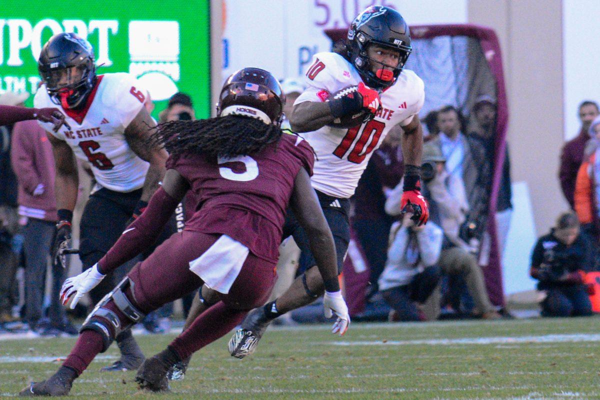 Freshman wide receiver Kevin "KC" Concepcion dodges opposing player during the game against Virginia Tech at Lane Stadium on Saturday, Nov. 18, 2023. Wolfpack beat the Hokies 35-28.