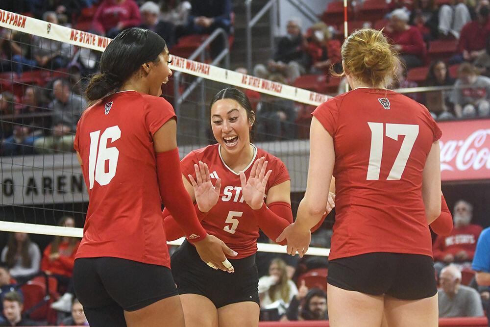 Graduate setter Kristen McDaniel (center) high-fives junior middle blocker Jada Allen (left) and junior opposite hitter Amanda Rice (right) in the match against Boston College inside Reynolds Coliseum on Friday, Nov. 3, 2023. NC State lost the match 3-2.