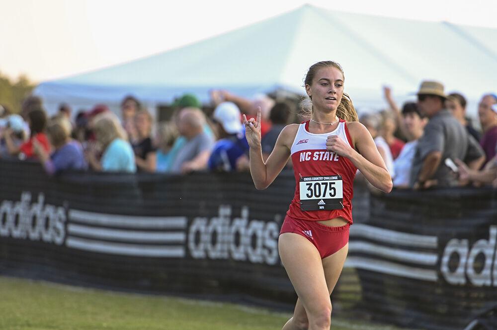 Senior Sam Bush puts up a wolfie after competing in the Adidas XC Challenge at Wake Med Soccer Park on Friday, Sept. 16, 2022. Bush finished first with a time of 16:14.5. The Wolfpack placed first in the men's and women's race.