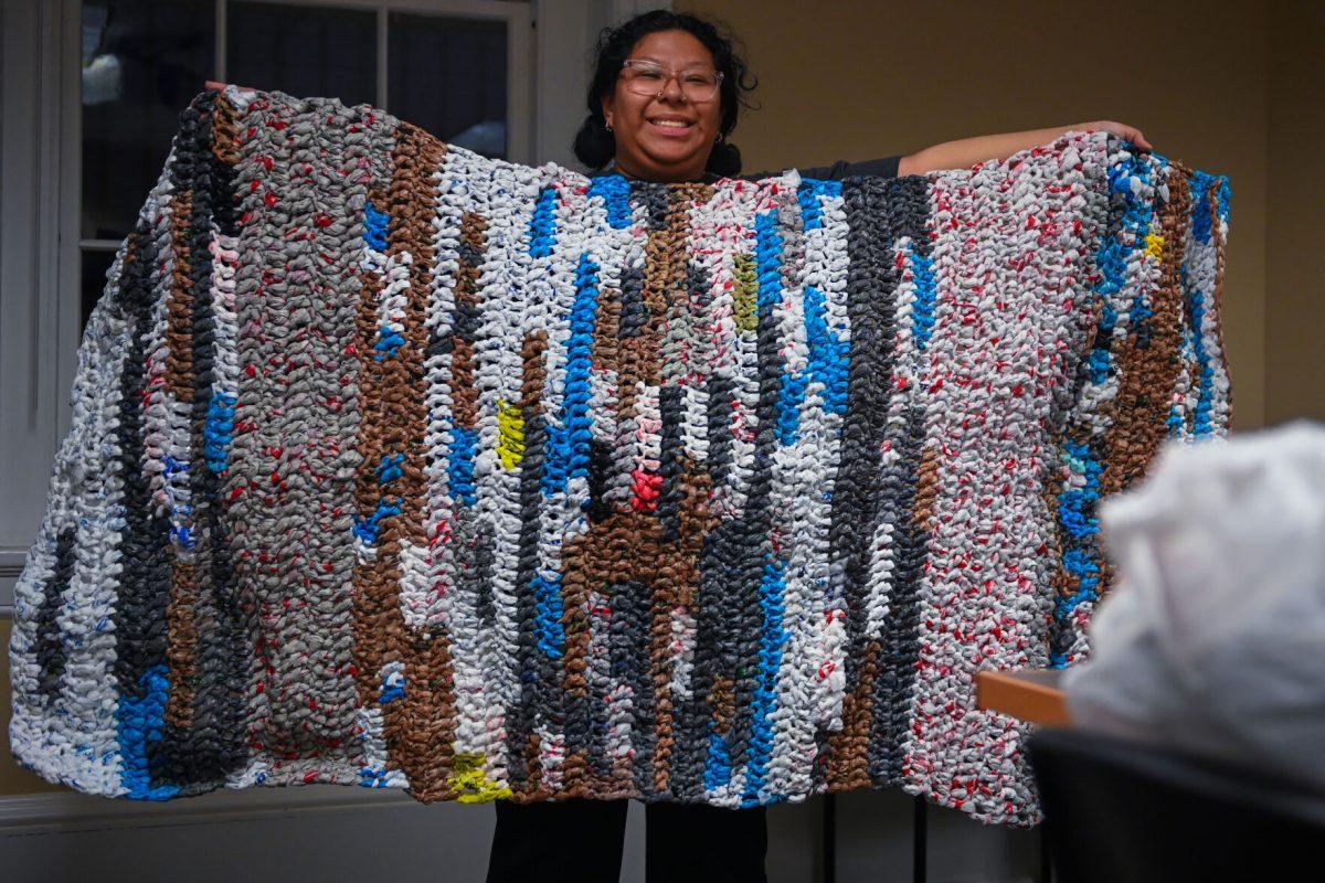 Paola Ramirez Hernandez, a second-year studying social work, holds up one of their bed mats during the Wolfpack Beds Club meeting at the 1911 Building on Thursday, Nov. 16, 2023. The goal of their club is to make crochet bed mats out of plastic bags for unhoused people in the area. The club provides all the materials needed for students to work on their own for this project.