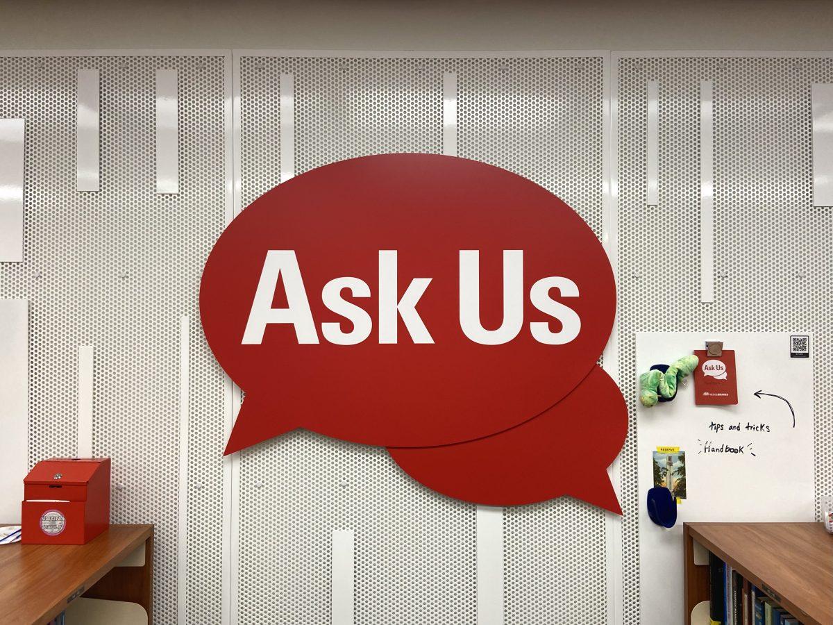 An "Ask Us" sign sits behind the new Ask Us desk in D.H. Hill Jr. Library on Monday, Nov. 14, 2023. The Ask Us desk allows visitors to borrow technology and ask general questions about the library.