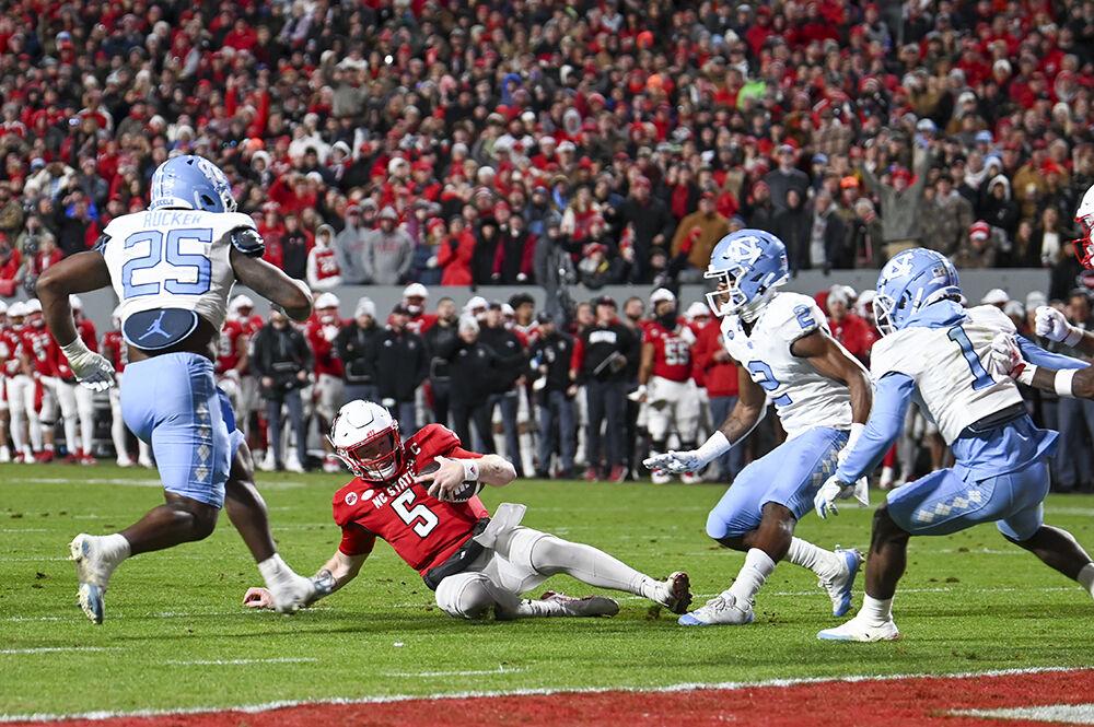 Graduate quarterback Brennan Armstrong slides to avoid UNC-Chapel Hill's defensive line during the game against UNC in Carter-Finley Stadium on Saturday, Nov. 25, 2023. The Wolfpack beat the Tarheels 39-20.