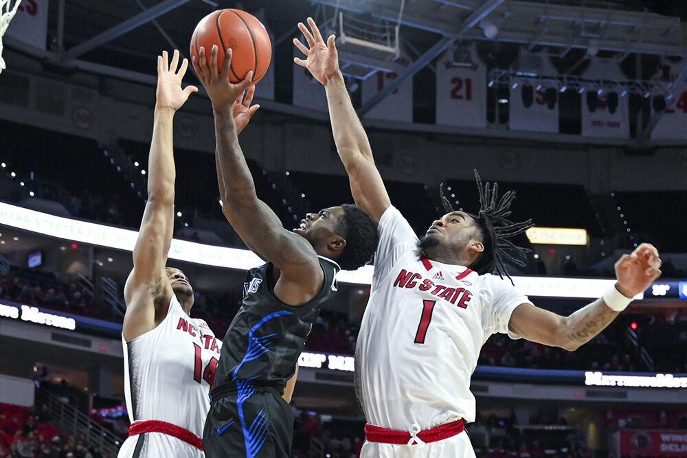 Graduate guard Casey Morsell and junior guard Jayden Taylor guard the opposing player during the game against Saint Louis in PNC Arena on Wednesday, Dec. 20, 2023. NC State beat Saint Louis 82-70.