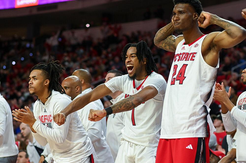 Junior guards Jayden Taylor and Breon Pass celebrate a Wolfpack basket with junior forward Ernest Ross during the game versus the Wake Forest Demon Deacons in PNC Arena on Tuesday, Jan. 16, 2024. The Wolfpack beat the Demon Deacons 83-76.
