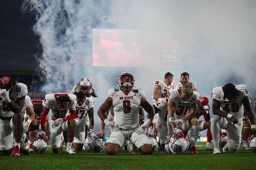 Members of the Wolfpack football team pray together before the Poptart Bowl between the NC State Wolfpack and the Kansas State Wildcats played in Camping World Stadium in Orlando, Florida on Thursday, Dec. 28, 2023. The Wildcats beat the Wolfpack 28-19.