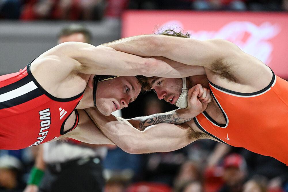 Redshirt junior Kai Orine locks arms with Oklahoma State redshirt senior Daton Fix during the duel in Reynolds Coliseum on Friday, Jan. 5, 2023. NC State lost to Oklahoma State 22-12.
