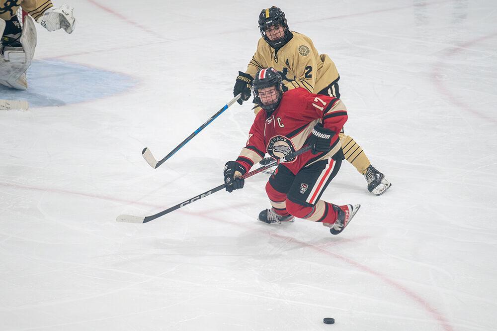 Senior forward Garrett Auriene locks eyes on the puck during the game against Wake Forest at Invisalign on Friday, January 19, 2024. NC State beat Wake Forest 7-2.