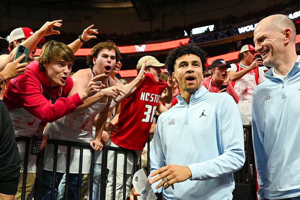 NC State fans heckle former UNC-Chapel Hill basketball player Marcus Paige and assistant coach Brad Federick before the game in PNC Arena on Wednesday, Jan. 10, 2024. The Tar Heels beat the Wolfpack 67-54.