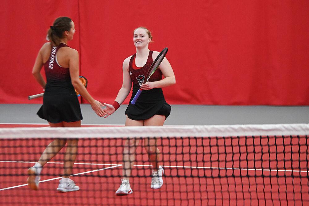 Sophomore Anna Zyryanova (left) high-fives senior Sophie Abrams (right) during their doubles match against Alabama at J.W. Isenhour Tennis Center on Saturday, Jan. 28, 2024. The pair won their doubles match 6-3. The Wolfpack won the overall match 4-0.