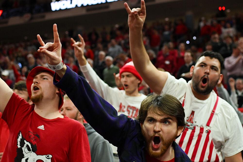 The NC State student section chant while holding up their wolfies during the final moments of the game versus the Wake Forest Demon Deacons in PNC Arena on Tuesday, Jan. 16, 2024. The Wolfpack beat the Demon Deacons 83-76.