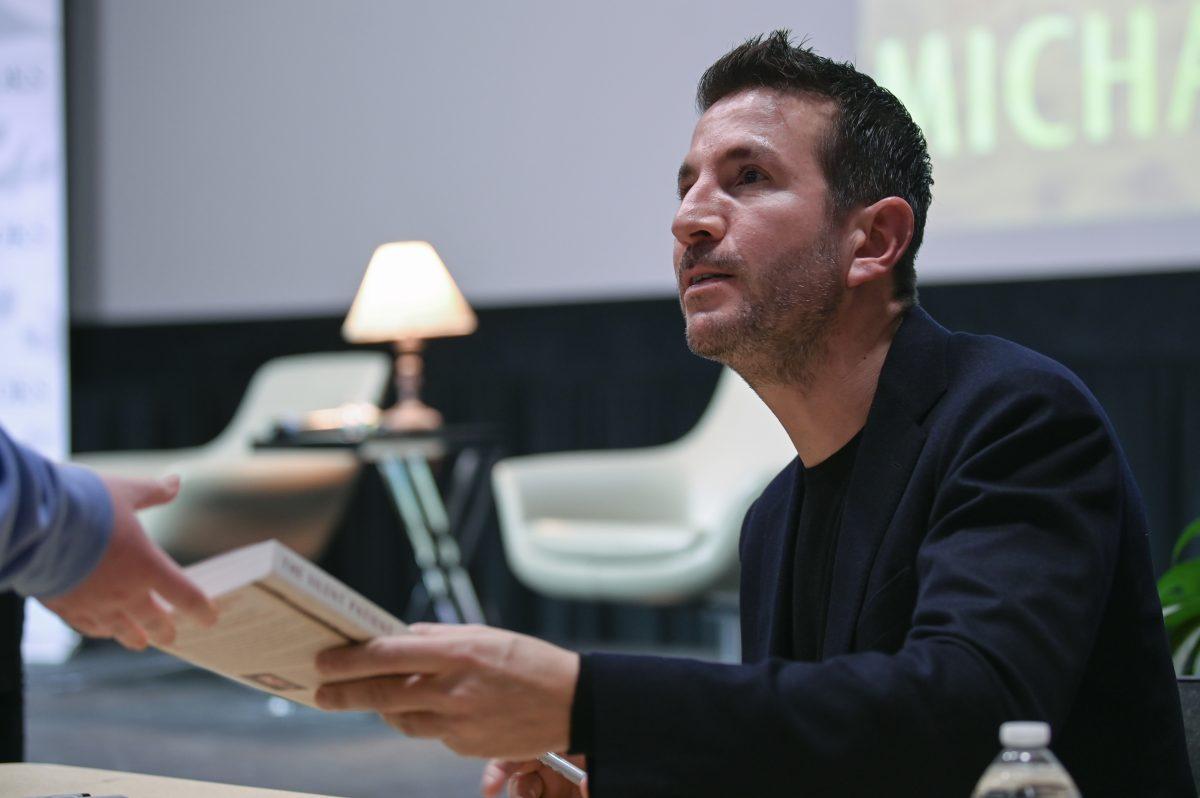 Alex Michaelides, #1 New York Times bestselling author of "The Silent Patient," hands his book to a reader after signing it during the Author Event in Witherspoon Student Center on Wednesday, Jan. 24, 2024. Michaelides spoke about his new book "The Fury" which was published earlier this year and signed books at the end of the event.