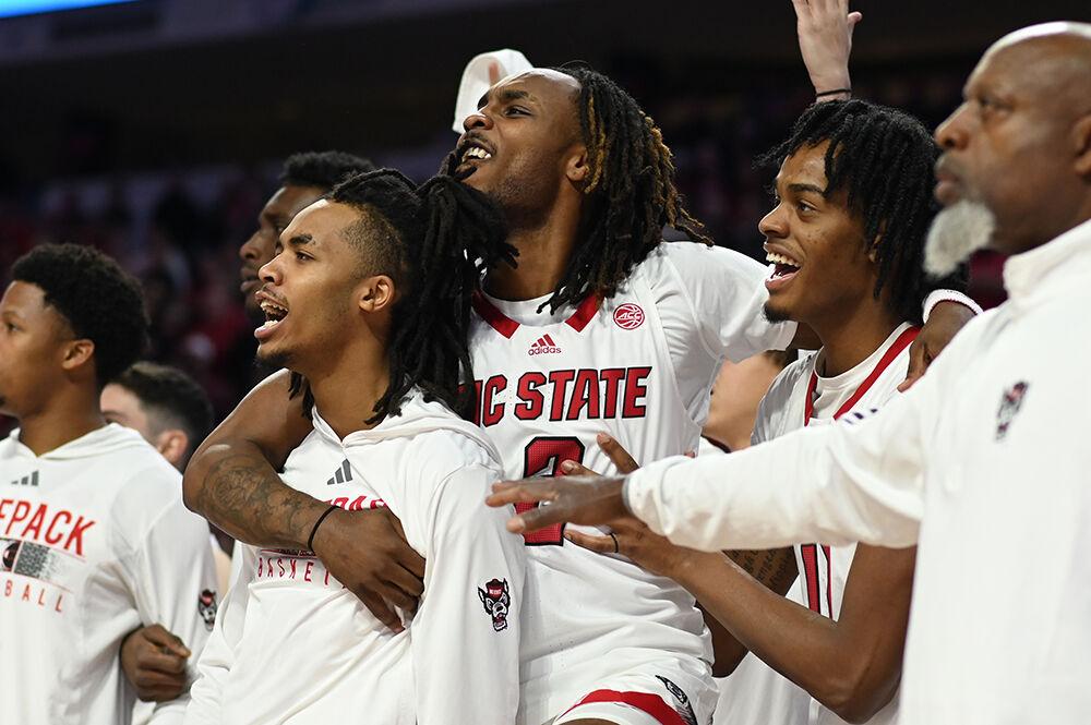 Junior guards Kam Woods and Breon Pass celebrate NC State's lead over the Wake Forest Demon Deacons with freshman guard Dennis Parker, Jr. in PNC Arena on Tuesday, Jan. 16, 2024. The Wolfpack beat the Demon Deacons 83-76.
