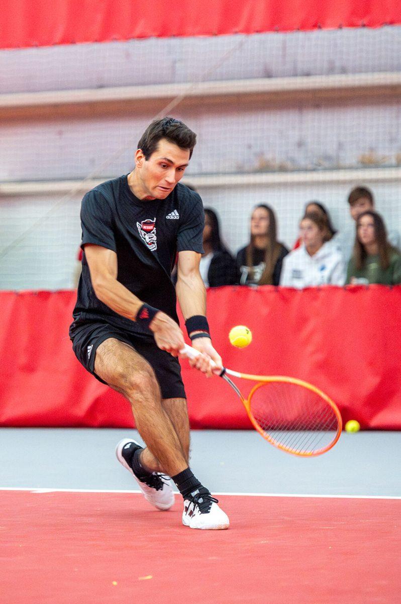 Senior Luca Staeheli backhands the ball during the match against Northwestern at J.W. Isenhour Tennis Center on Monday, Jan. 15, 2024. Staeheli won his singles 7-6 (7-2), 6-4. NC State won 6-1 against Northwestern.