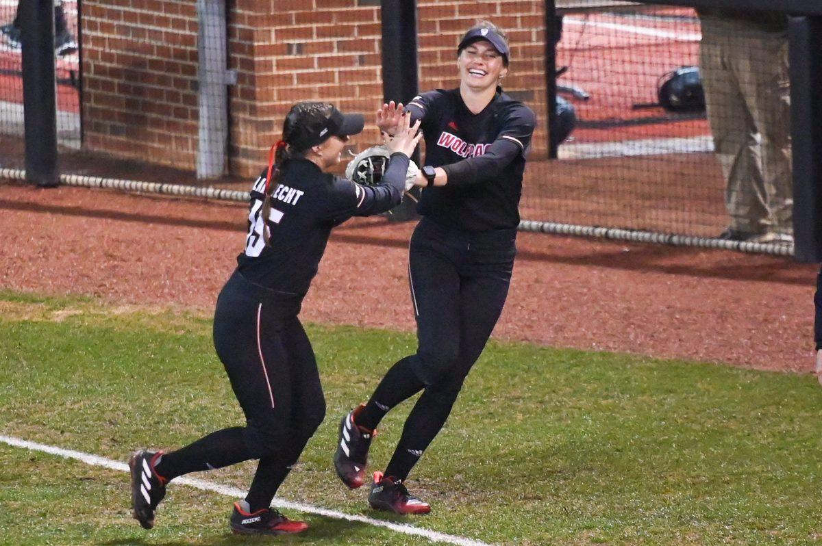 Senior infielder Kaylee Lambrecht and Junior outfielder Taylor Ensley high five after recording the last out of an inning during the game against Albany in Dail Softball Stadium on Friday, Feb. 23, 2024. The Wolfpack defeated the Great Danes 9-0 (5).