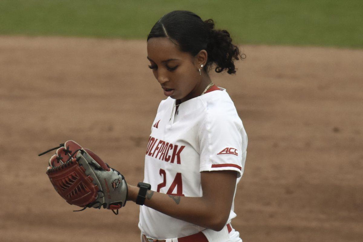 Senior pitcher Aisha Weixlmann glaces at her sign card during the game against North Dakota State at Dail Softball Stadium on Friday, Feb. 16, 2024. Weixlmann is a right-handed pitcher for NC State. NC State beat North Dakota State 6-4.