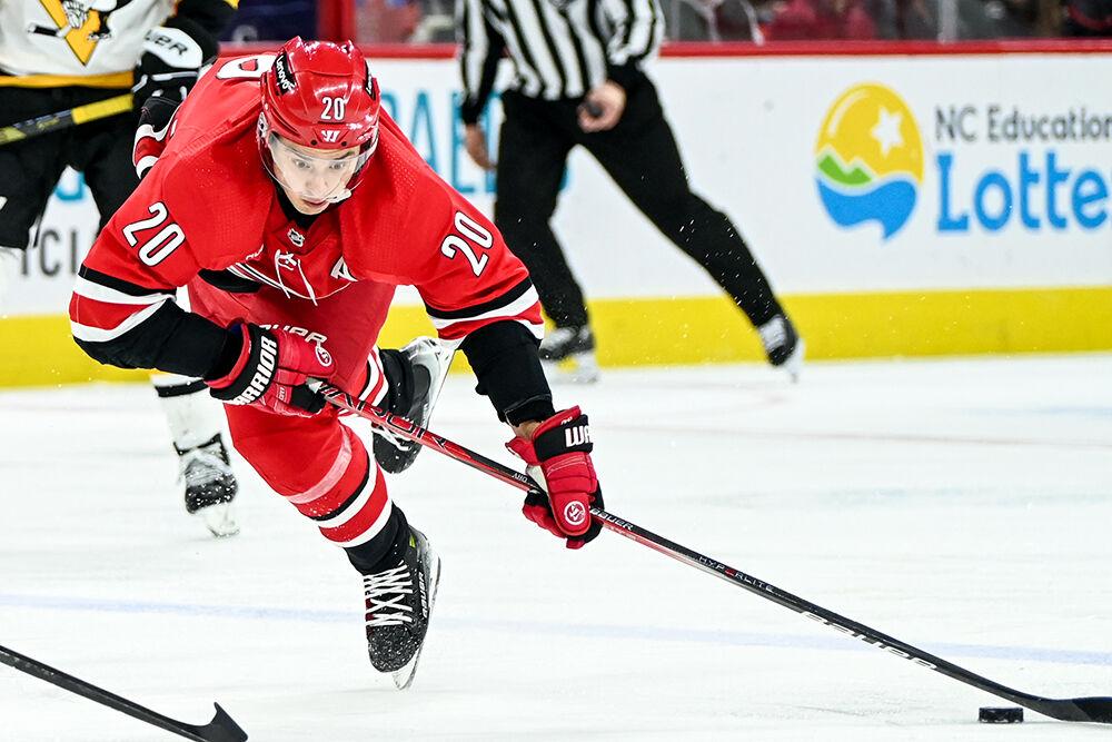 Carolina Hurricanes center Sebastian Aho falls to the ground while moving the puck down the ice during the game against the Pittsburgh Penguins in PNC Arena on Saturday, Jan. 13, 2024. Aho assisted one goal. The Hurricanes beat the Penguins 3-2 in overtime.