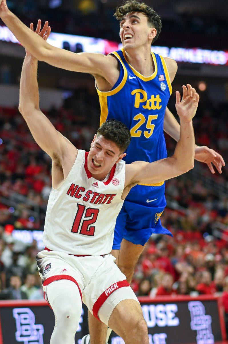 Graduate guard Michael O'Connell is hit by Pittsburgh sophomore forward Guillermo Diaz Graham in PNC Arena on Wednesday, Feb. 7, 2024. O'Connell had five rebounds and four assists against Pittsburgh. The Panthers beat the Wolfpack 67-64.