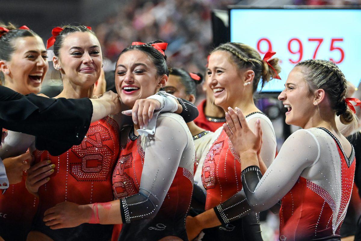 The team surrounds graduate Emily Shepard after scoring her personal best on the uneven bars during the meet against Clemson in Reynolds Coliseum on Saturday, Feb. 17, 2024. Shepard had an all-around score of 9.850, the highest in program history. NC State beat Clemson 197.575-196.000 to be crowned ACC Regular Season Champions.