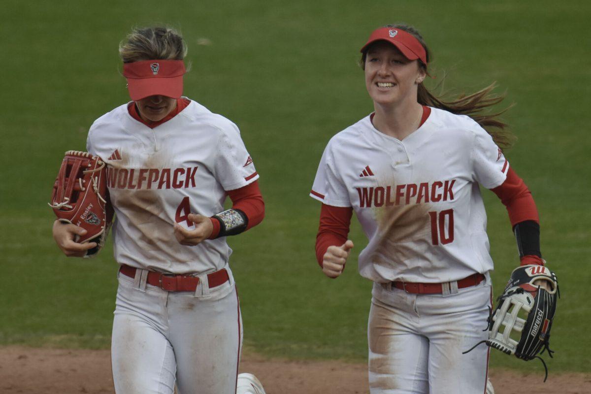 Freshman left fielder Tori Ensley and sophomore center fielder Ellie Goins jog with smiles during the game against North Dakota State at Dail Softball Stadium on Friday, Feb. 16, 2024. Both Goins and Ensley had one double base hit. NC State beat North Dakota State 6-4.