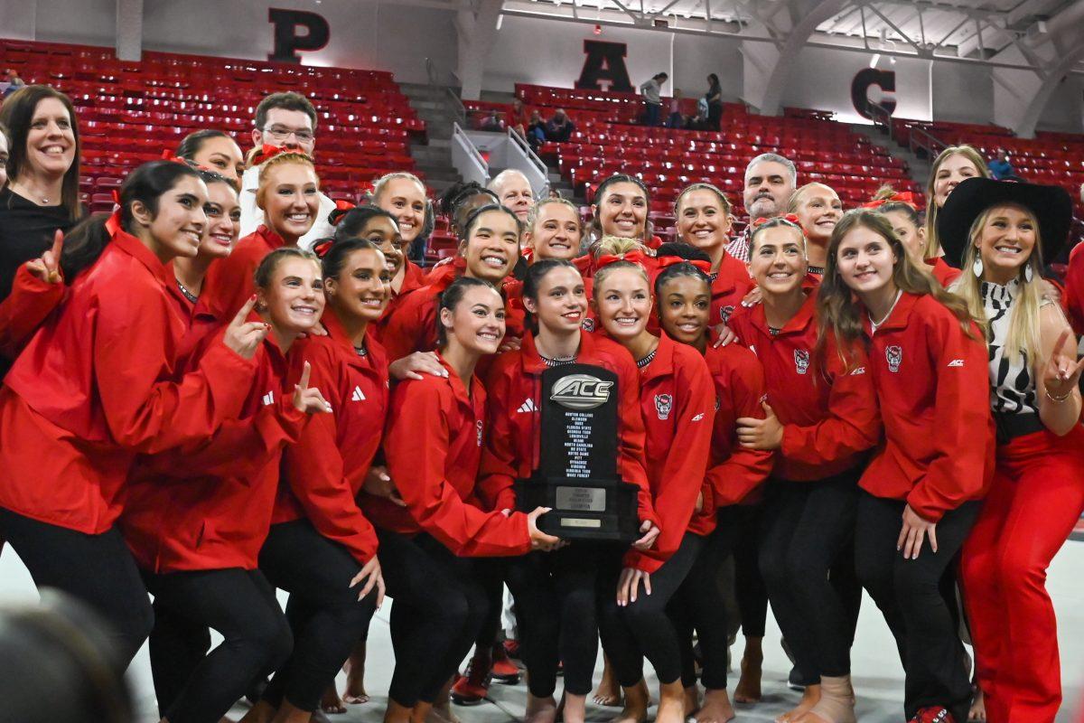 The NC State Gymnastics team poses for a picture with their ACC Regular Season Champions trophy after the meet against Clemson in Reynolds Coliseum on Saturday, Feb. 17, 2024. NC State beat Clemson 197.575-196.000.