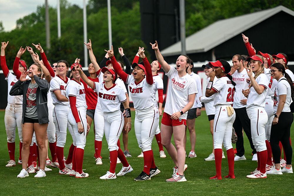The NC State softball team cheers and hold up "wolfies" to the stands after the game against Clemson at Dail Softball Stadium on Sunday, April 16, 2023. NC State beat Clemson 7-5.