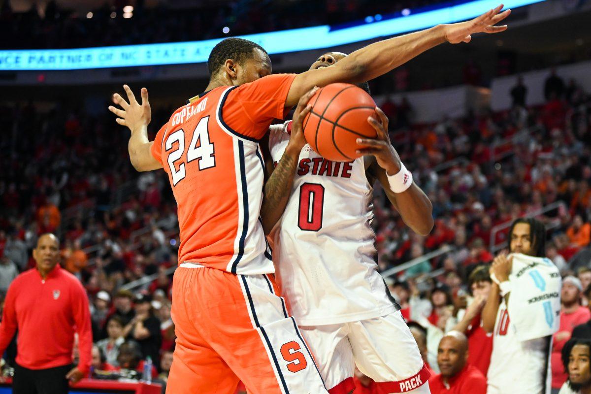 Graduate guard DJ Horne attempts to draw a foul on NC State's final possession during the game against Syracuse in PNC Arena on Tuesday, Feb. 20, 2024. The Orange defeated the Wolfpack 87-83.