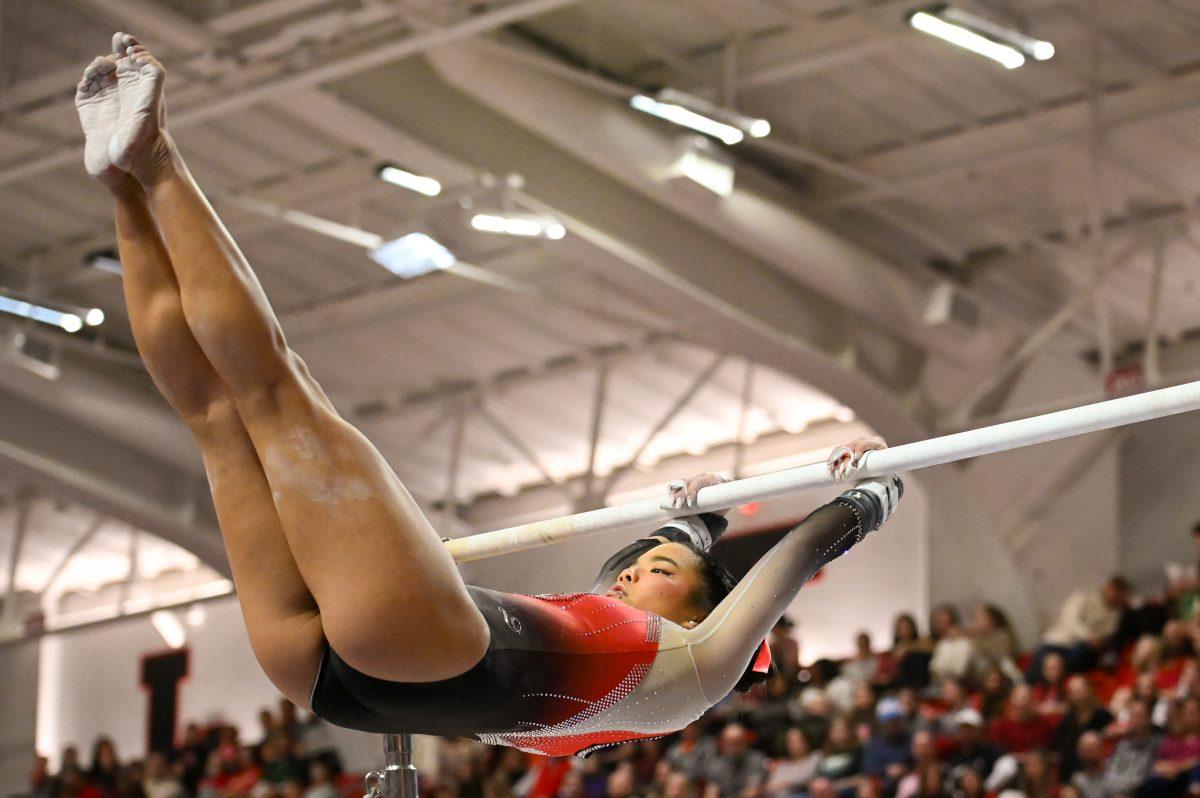 Freshman Maddie Hall spins around the uneven bars during the meet against Clemson in Reynolds Coliseum on Saturday, Feb. 17, 2024. NC State beat Clemson 197.575-196.000.
