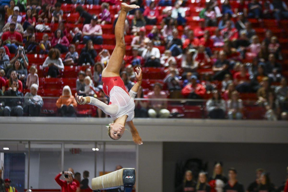 Junior Macy Jennings does an aerial cartwheel on the beam during the meet against UNC-Chapel Hill in Reynolds Coliseum on Sunday, Feb. 11, 2024. Jennings scored a 9.900 average on the balance beam. NC State beat UNC 196.725-194.925