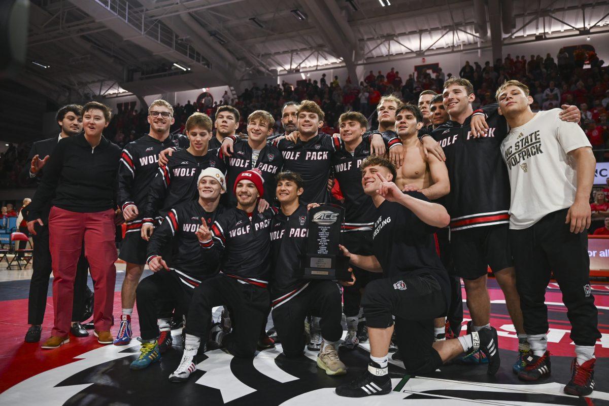 The NC State Wrestling team celebrates winning the ACC regular season dual meet championship in Reynolds Coliseum on Friday, Feb. 23, 2024. NC State beat Virginia Tech 20-12.